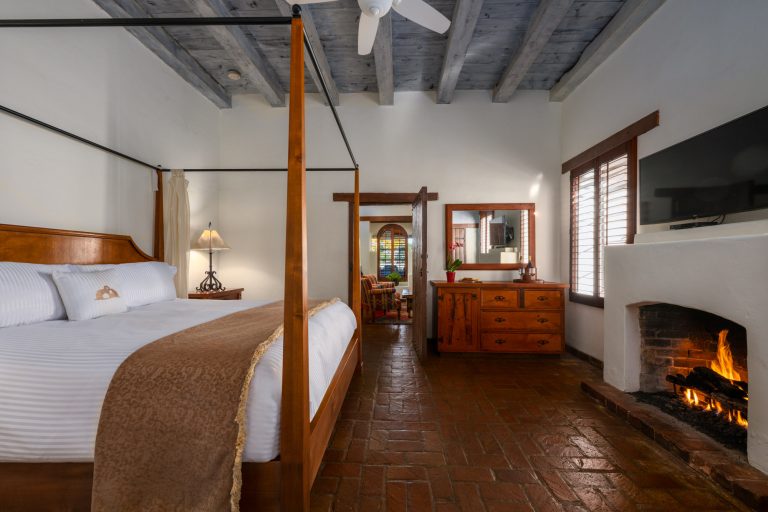 Casita bedroom with a four poster bed and a lit fireplace